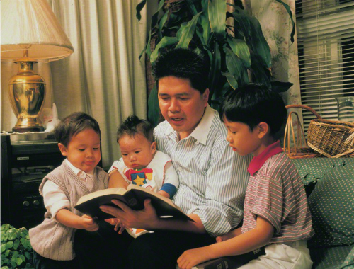 子供に本を読み聞かせる父親 神への信仰