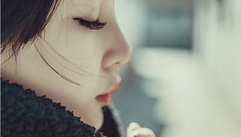 目を閉じて祈る女性
