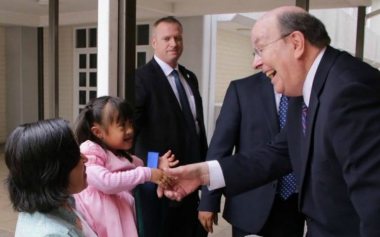 幼い少女と握手を交わすクエンティン・L・クック長老