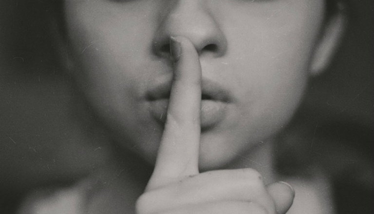 人差し指を口に当てた人のクロースップ写真